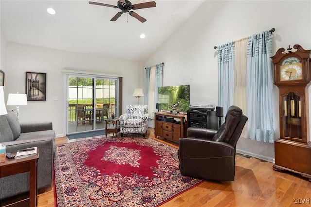 living room featuring ceiling fan, wood-type flooring, and vaulted ceiling