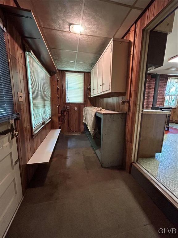 laundry area with a wood stove and wood walls