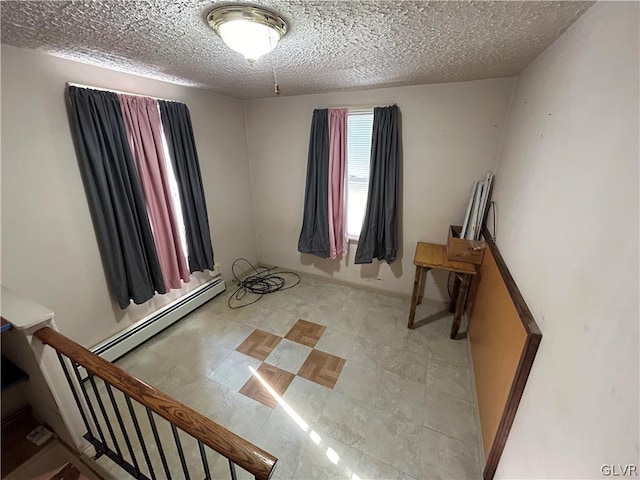 bedroom with a textured ceiling, a baseboard radiator, and light tile patterned floors