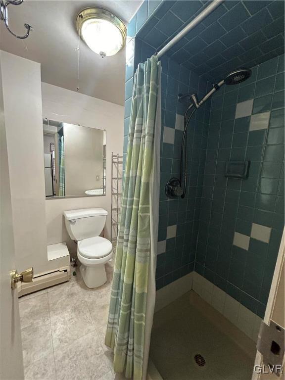 bathroom featuring a baseboard heating unit, toilet, a shower with shower curtain, and tile patterned floors