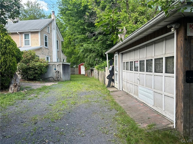 view of property exterior with a storage unit and a garage