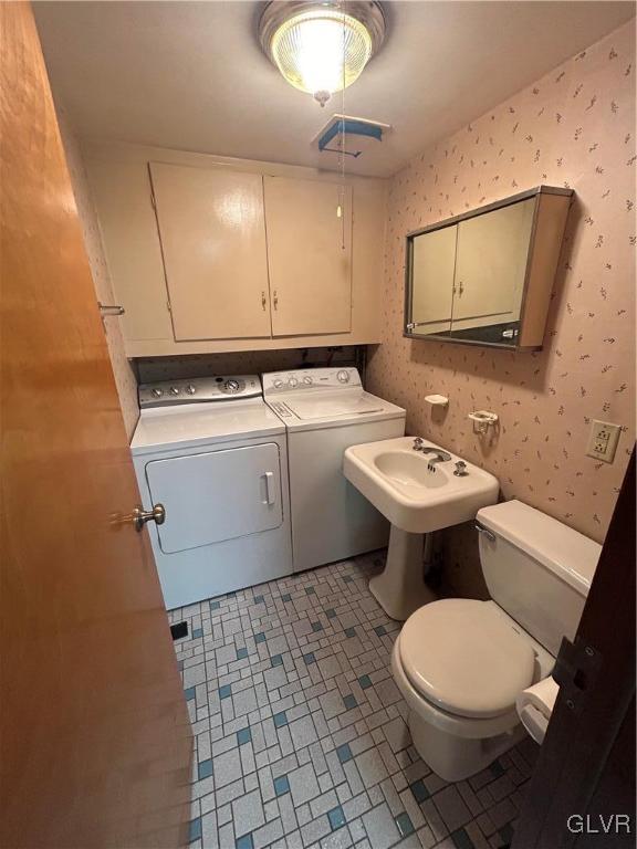 bathroom with tile patterned flooring, toilet, and washing machine and clothes dryer