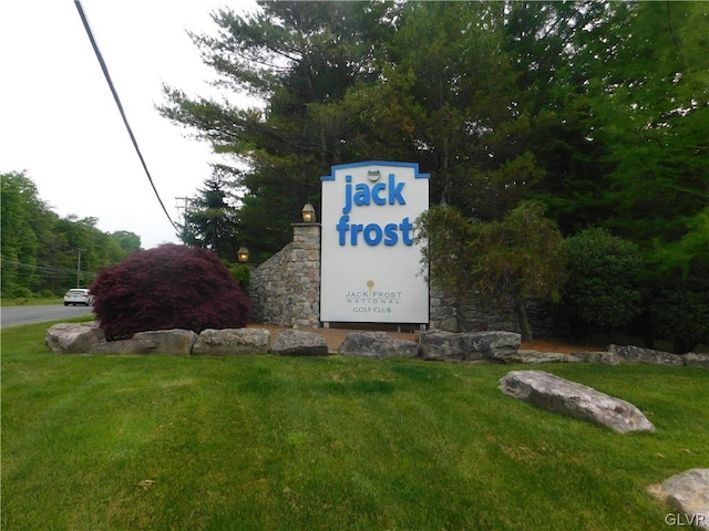 community / neighborhood sign featuring a yard