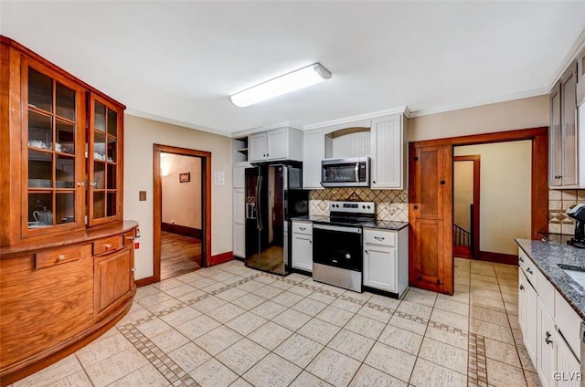 kitchen with light tile patterned floors, backsplash, white cabinets, and stainless steel appliances