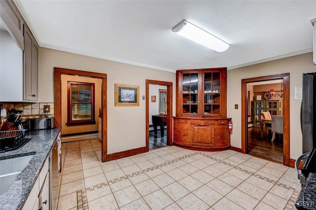 kitchen with decorative backsplash, white cabinets, stainless steel dishwasher, light hardwood / wood-style floors, and ornamental molding