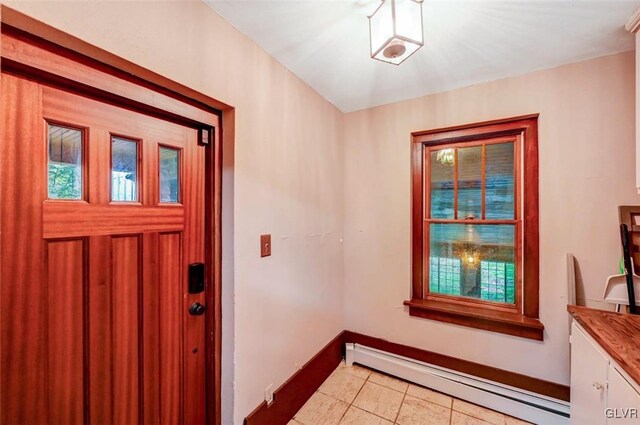 tiled entryway with a baseboard heating unit