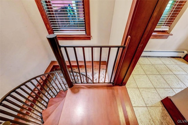 stairs featuring a baseboard radiator and tile patterned flooring