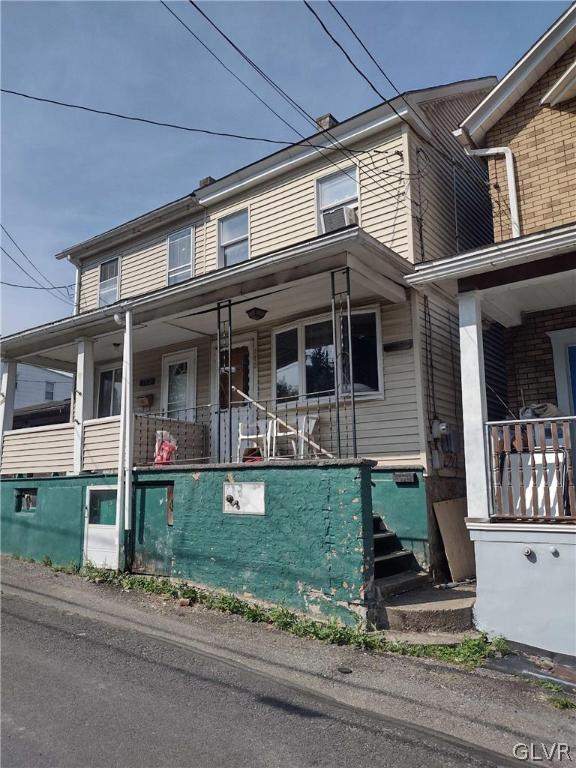 view of property featuring covered porch and cooling unit