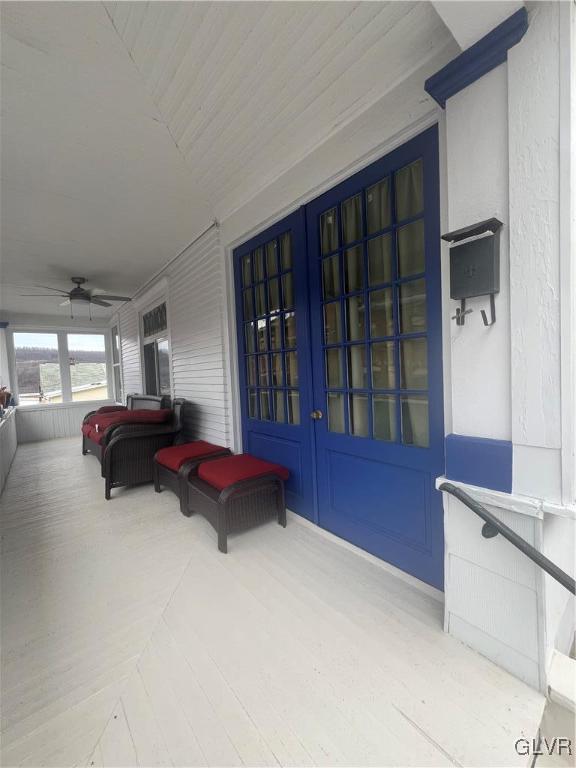 entrance to property featuring ceiling fan, french doors, and a porch