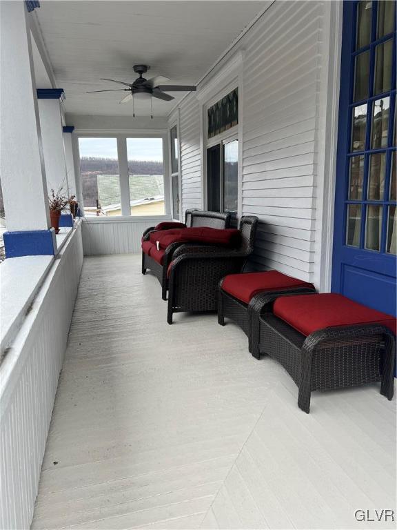 sunroom / solarium with a water view and ceiling fan