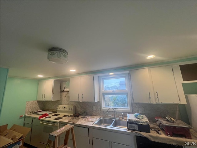 kitchen with tasteful backsplash, white electric range oven, wall chimney range hood, sink, and white cabinets