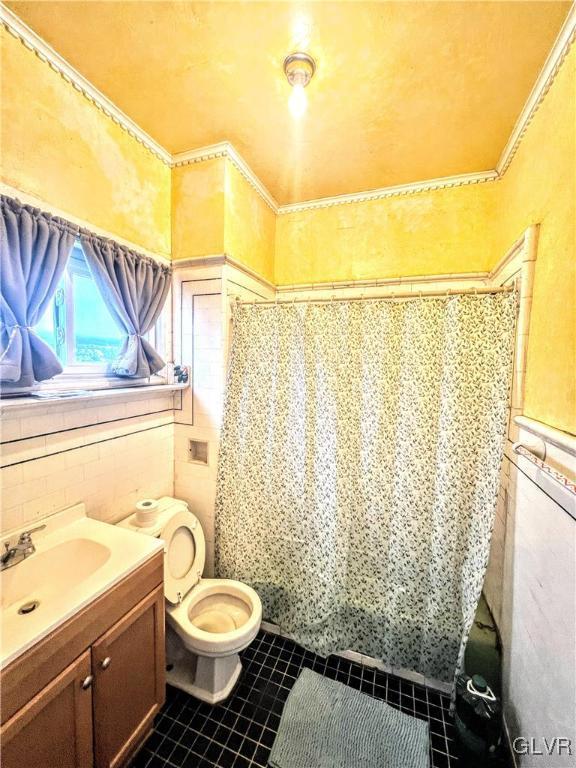 55 S Walnut St, Lansford Borough, PA 18232 - bathroom with toilet, a wainscoted wall, tile patterned floors, vanity, and tile walls