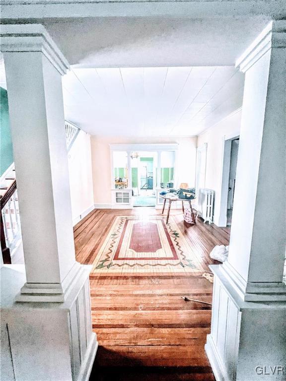 55 S Walnut St, Lansford Borough, PA 18232 - hallway with ornate columns, radiator heating unit, stairway, and wood finished floors