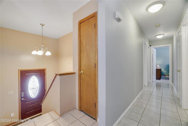 tiled foyer with a chandelier