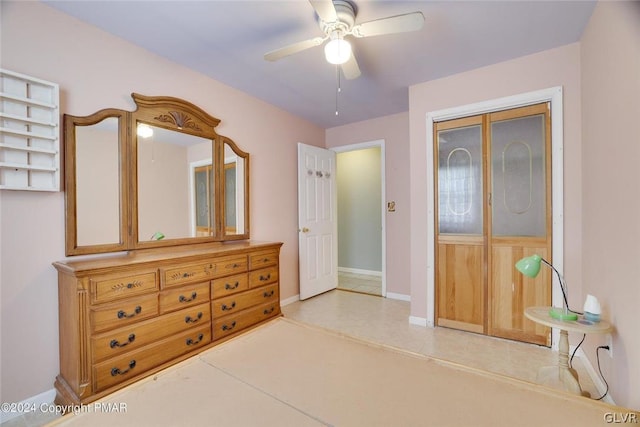 tiled bedroom with ceiling fan and a closet