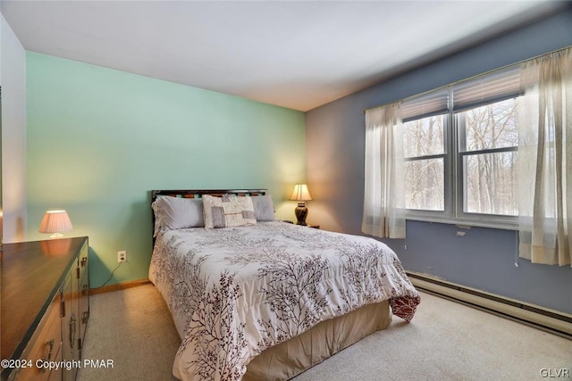 bedroom featuring a baseboard heating unit and light colored carpet