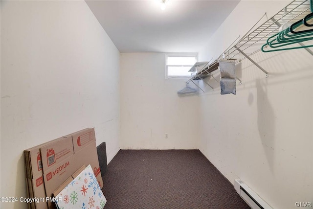 spacious closet with baseboard heating and dark colored carpet