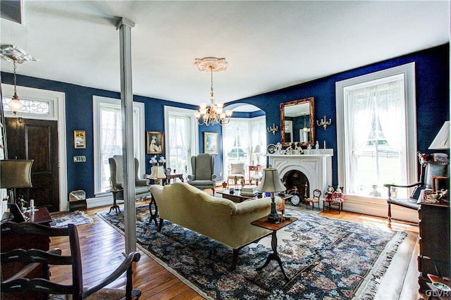 living room with hardwood / wood-style flooring, a healthy amount of sunlight, and a chandelier