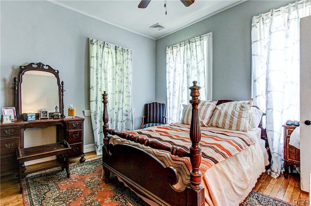 bedroom featuring crown molding, ceiling fan, and wood-type flooring