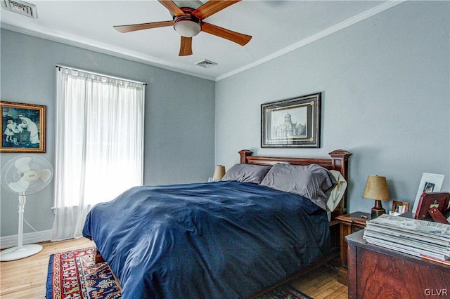 bedroom with crown molding, multiple windows, light wood-type flooring, and ceiling fan