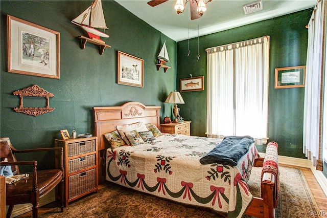 bedroom with dark hardwood / wood-style floors and ceiling fan