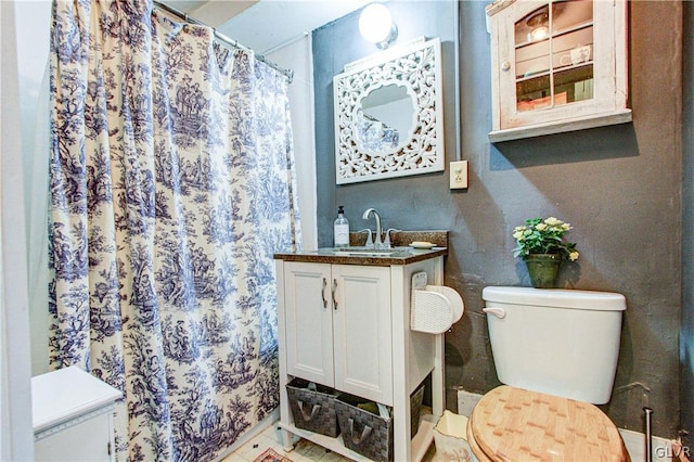 bathroom featuring tile patterned flooring, toilet, and vanity