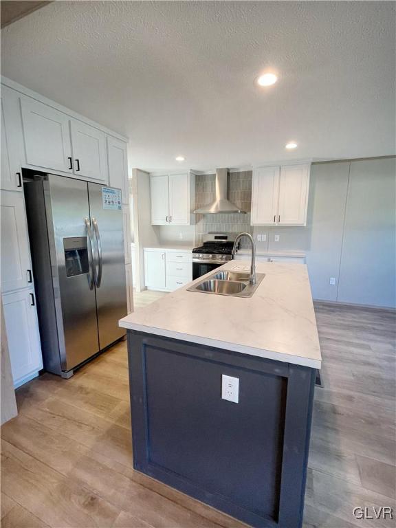 3444 Franklin Sq, Moore Twp, PA 18067 - kitchen with wall chimney exhaust hood, appliances with stainless steel finishes, light wood-style floors, white cabinetry, and light countertops