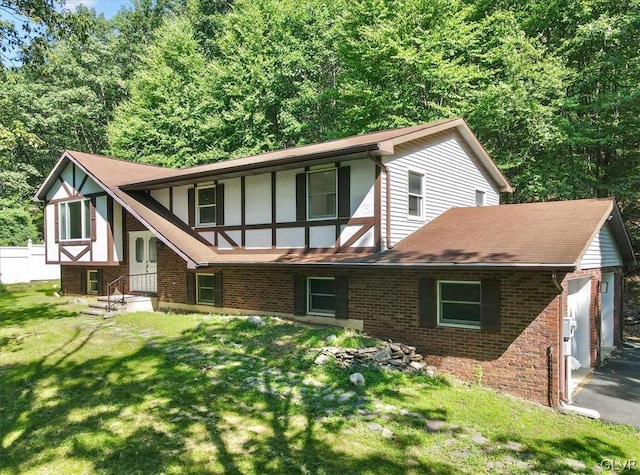 back of house featuring a lawn and a garage