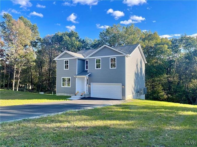 front of property with a front yard, a garage, and central AC