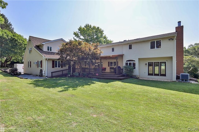 back of property featuring central AC unit and a yard