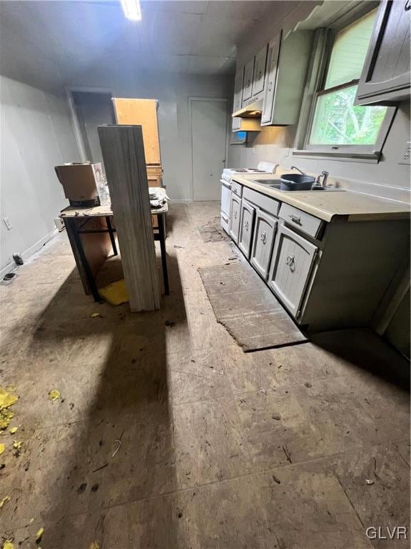 kitchen featuring white range, gray cabinetry, and sink