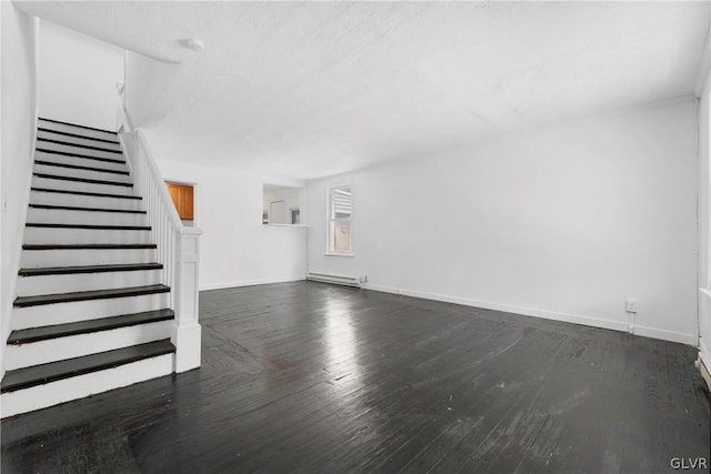 unfurnished living room featuring baseboard heating and dark hardwood / wood-style flooring