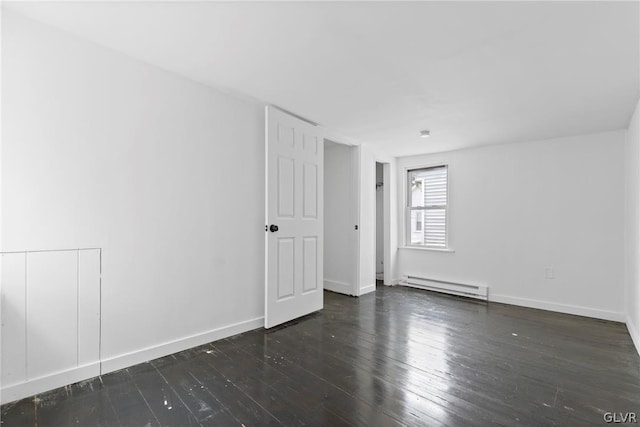 empty room featuring dark wood-type flooring and a baseboard radiator