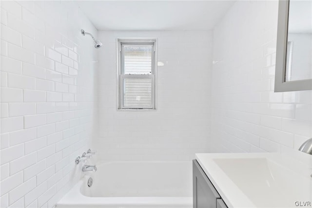 bathroom featuring tile walls, tiled shower / bath combo, and vanity