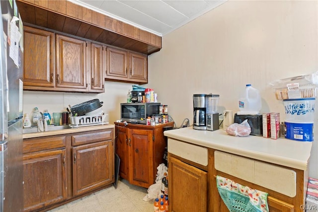 kitchen featuring light tile patterned floors, appliances with stainless steel finishes, and ornamental molding