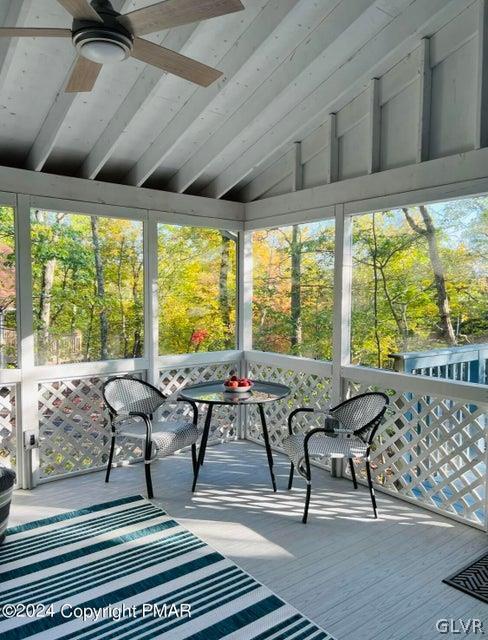 sunroom with lofted ceiling and ceiling fan