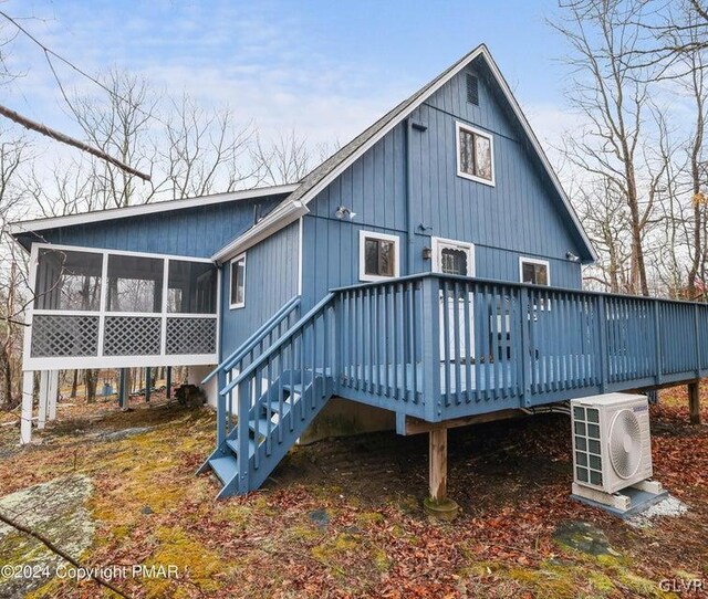 back of house with a sunroom, a wooden deck, and central AC unit