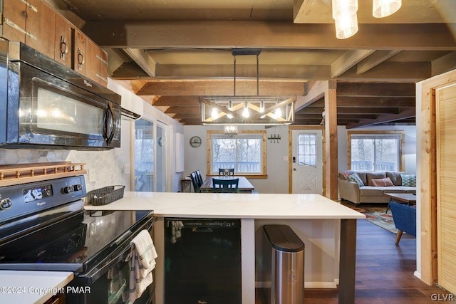 kitchen featuring pendant lighting, a wealth of natural light, dark wood-type flooring, and black appliances