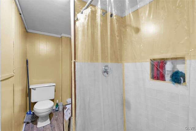 bathroom with hardwood / wood-style floors, a shower with curtain, crown molding, and toilet