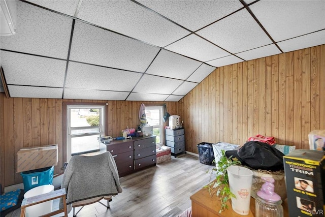 office space featuring wooden walls, wood-type flooring, and vaulted ceiling