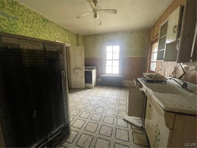 kitchen featuring light tile patterned flooring, ceiling fan, radiator heating unit, tile countertops, and a textured ceiling