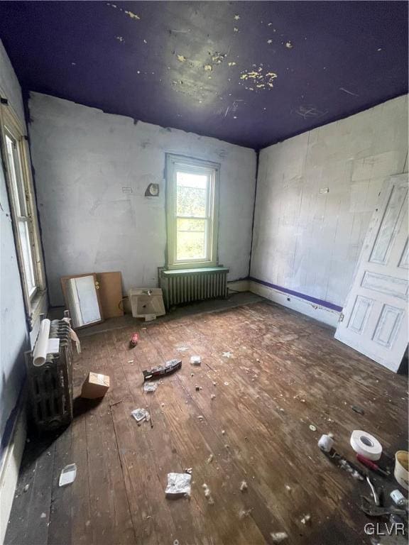 interior space featuring radiator heating unit and hardwood / wood-style flooring