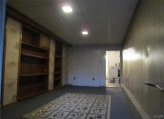 spare room featuring wooden walls and a paneled ceiling