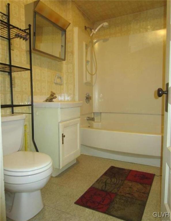 full bathroom with vanity, toilet, and washtub / shower combination