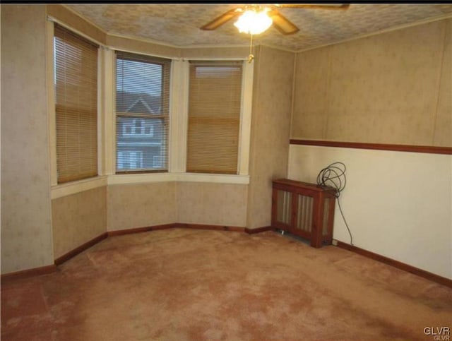 carpeted empty room featuring ceiling fan and a textured ceiling