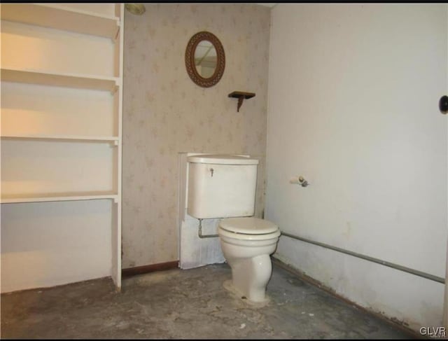 bathroom with concrete floors and toilet