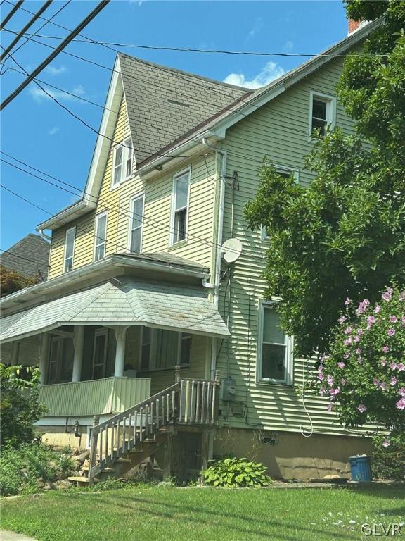 view of property exterior featuring a yard and a porch