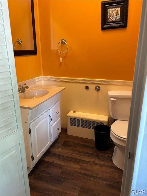 bathroom with hardwood / wood-style flooring, toilet, and vanity