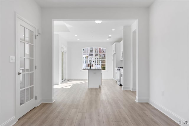 hall with light wood-type flooring and sink