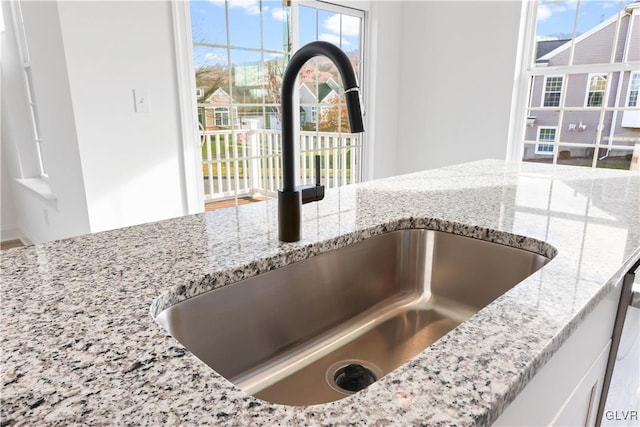 interior details with light stone countertops and sink